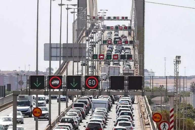 Impactante caos en el Puente del Centenario: tres jóvenes cruzan la SE-30 a pie con patinete